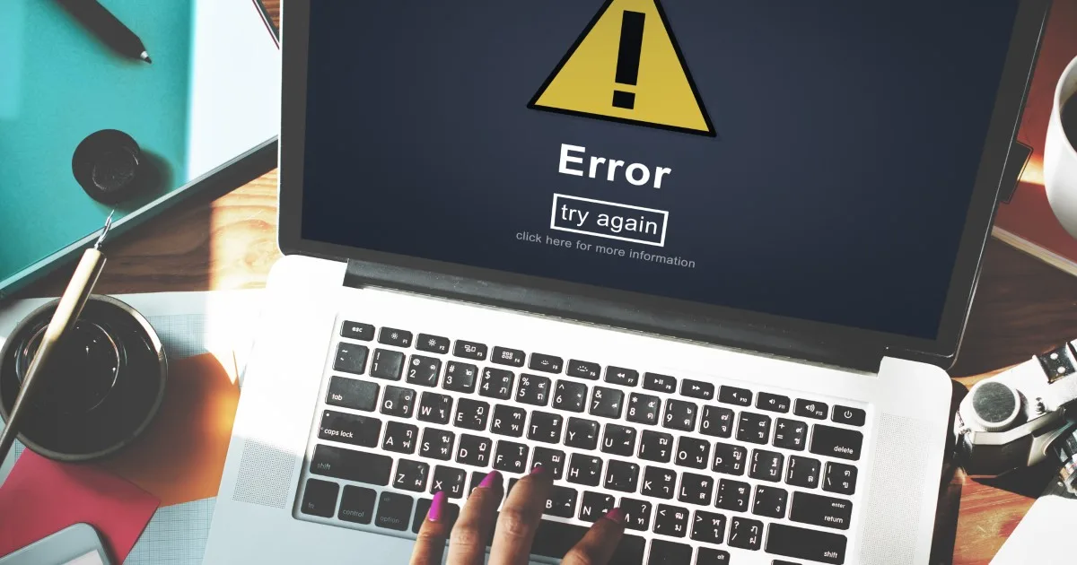 A laptop on a wooden desk displays a prominent 'Error' message on its screen