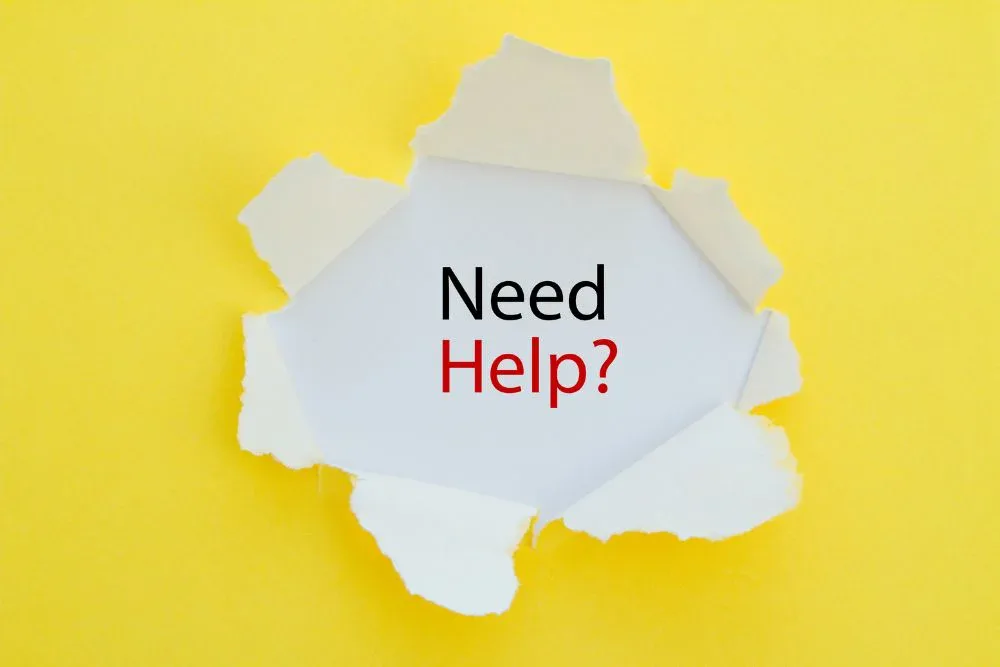 A bright yellow piece of paper with a jagged hole torn in the centre, revealing a white background underneath.