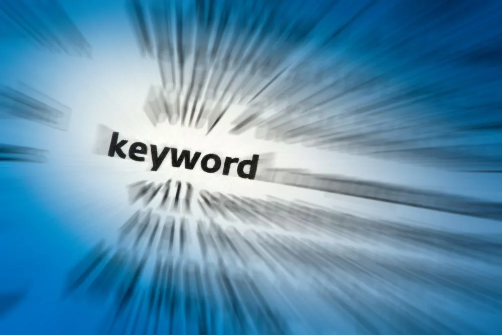 A dramatic, high-angle shot of the word "keyword" printed on a page, with a heavy zoom-blur effect radiating outward.