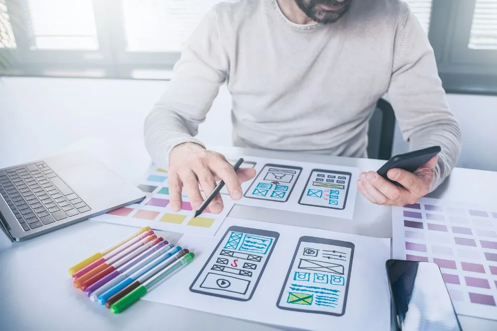 A first-person perspective of a designer working at a bright desk