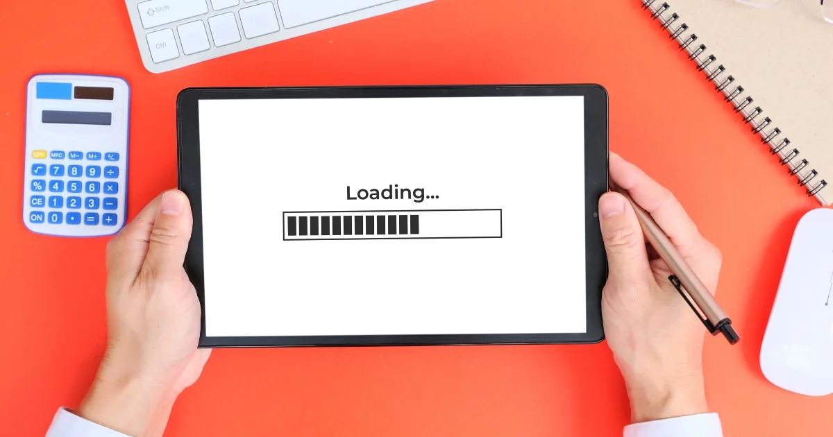 A person holding a tablet that displays a 'Loading...' screen with a progress bar.