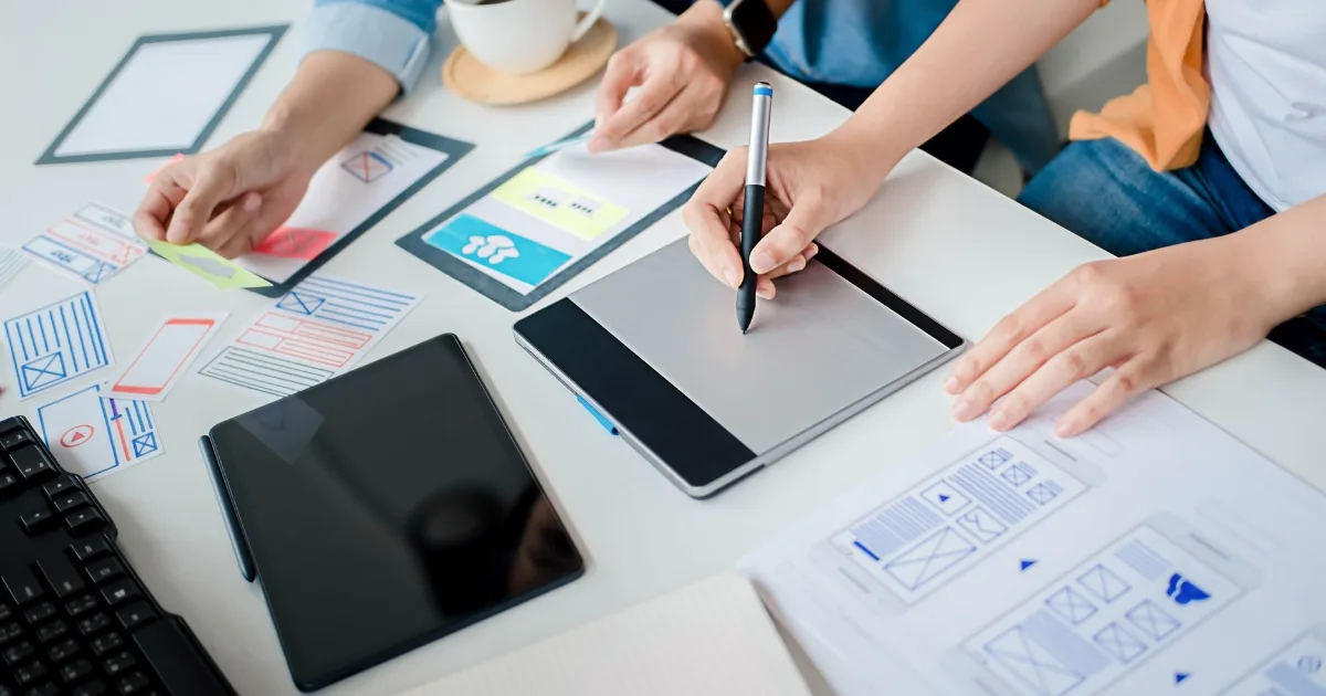 Two designers collaborating at a white desk