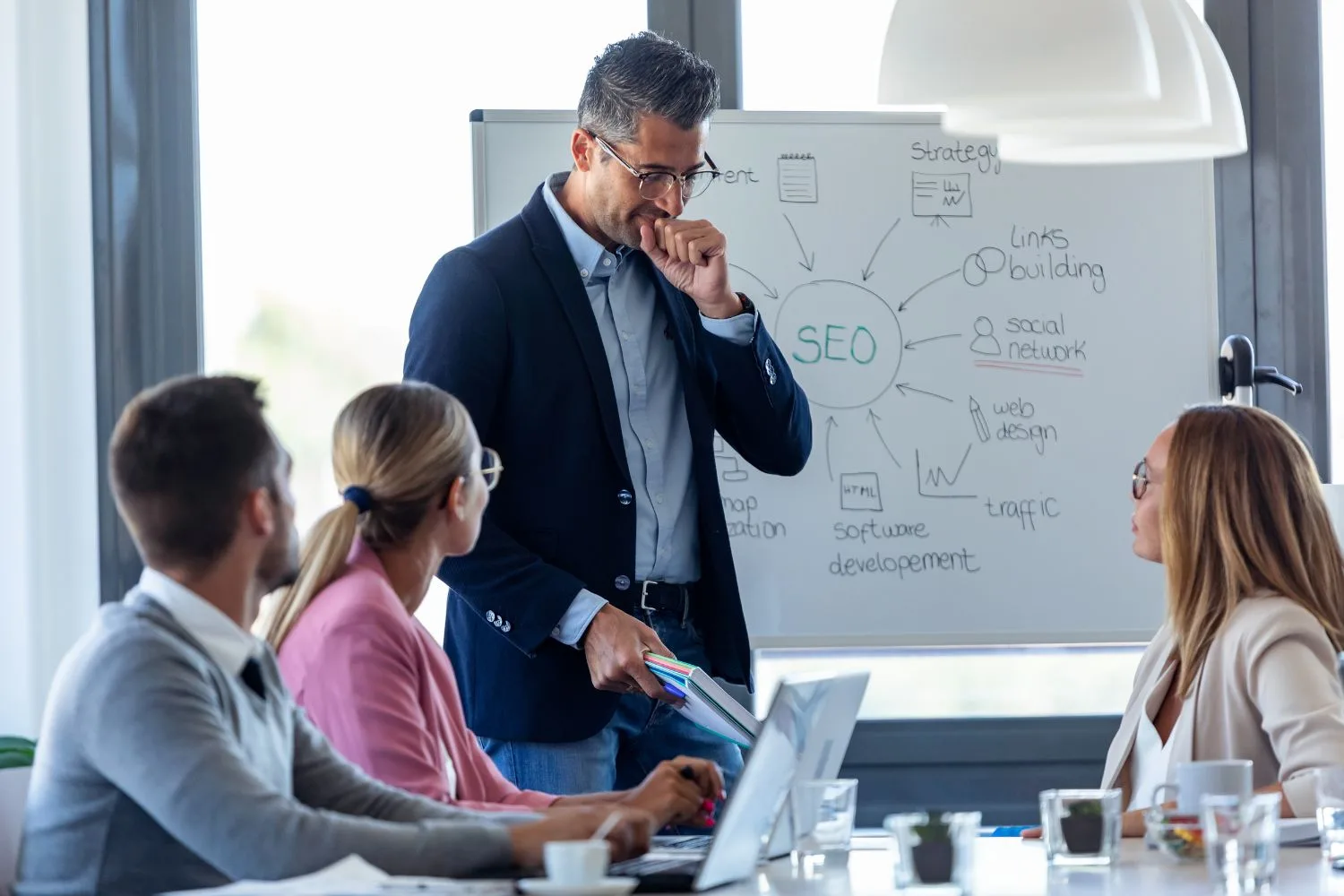 A professional business team holding a meeting in a bright office.
