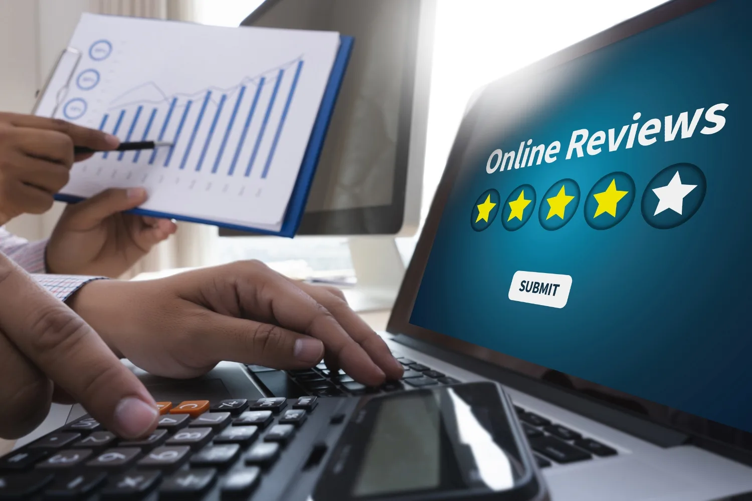 a laptop showing good reviews and a paper showing analytics