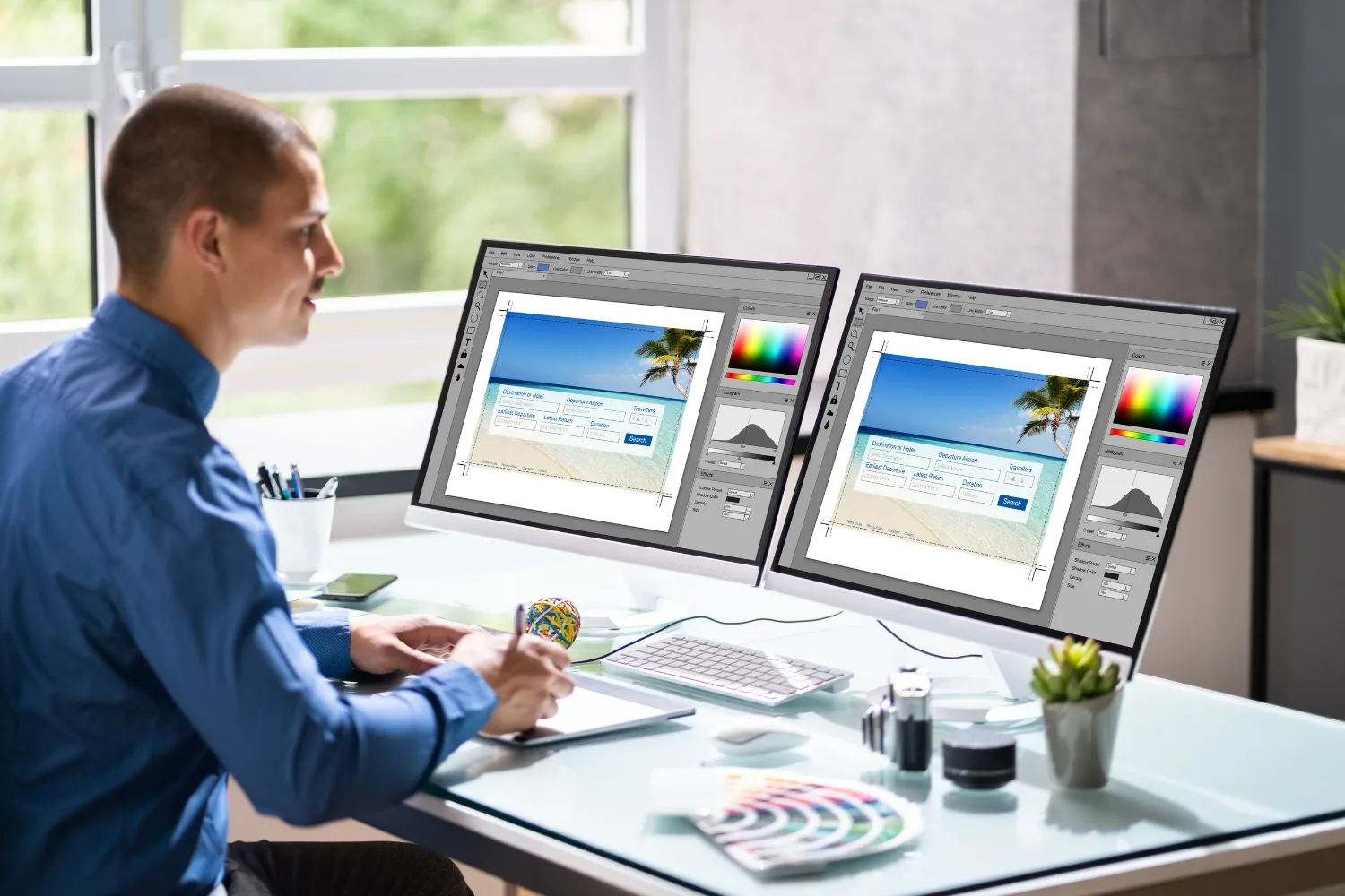A web designer reviewing custom wireframe layouts and a brand colour system on a large monitor in a studio environment, representing the planning and design process involved in building a custom website for a small business